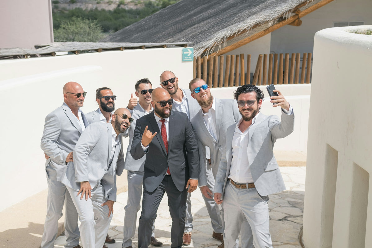 Groomsmen in light grey suits celebrating together